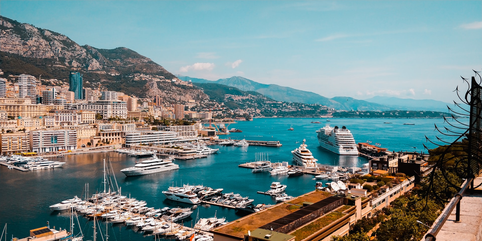 Een haven vol jachten en een cruiseschip in Monaco